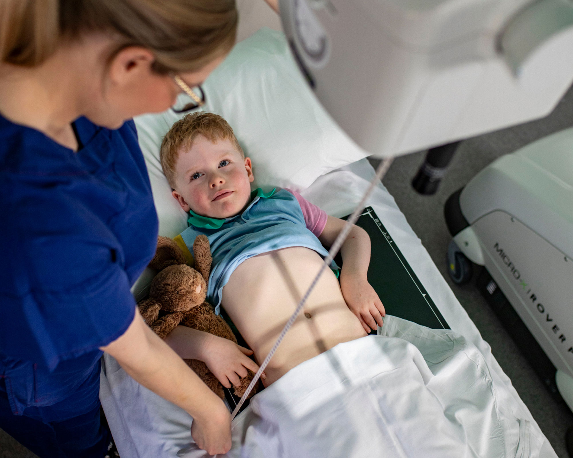 Micro-X Rover Plus mobile digital X-ray system being positioned at the bedside of a pediatric ICU patient in a quiet hospital ward